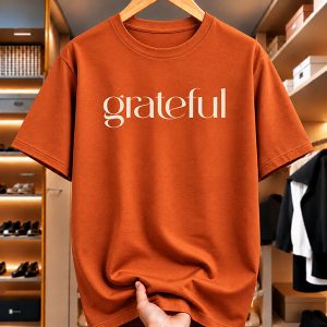 Burnt orange GRATEFUL T-shirt with cream lettering by Penpoint Studios.